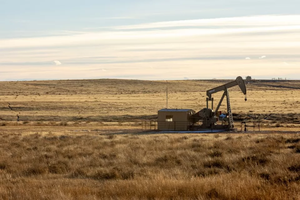 Oil well in prairie landscape.